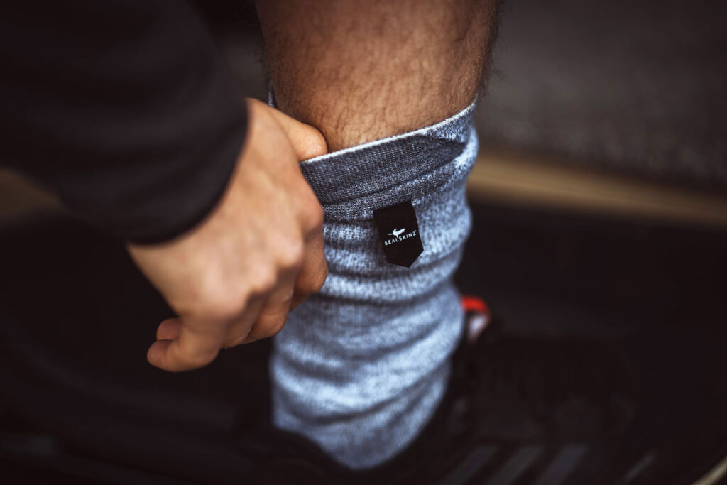 A man putting on a pair of the waterproof socks