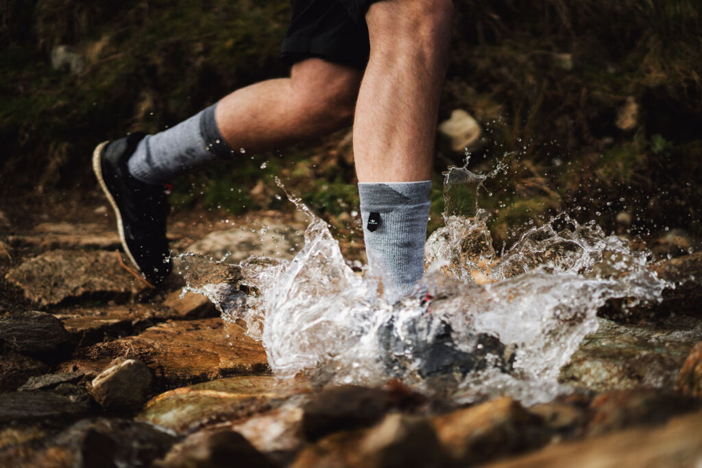 Runner splashing through a river wearing the Waterproof All Weather Mid Length Socks