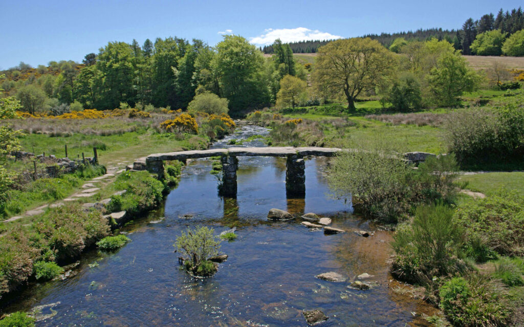 A beautiful view up a river in the countryside towards a bridge