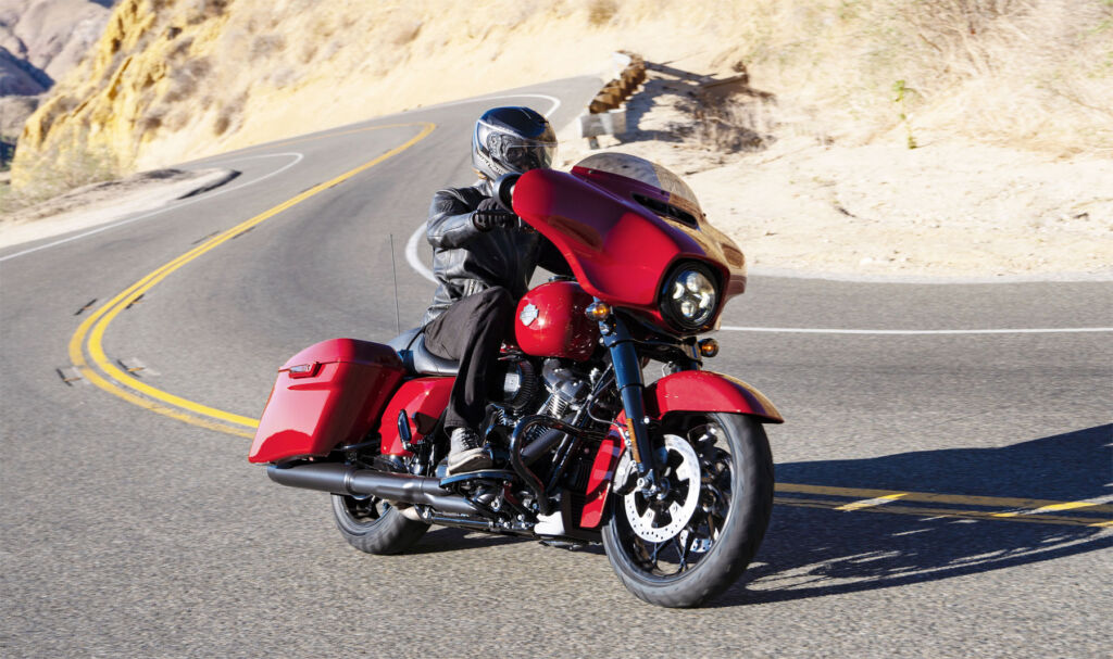 A 2021 Harley-Davidson Street Glide Special in red taking a corner on an American road