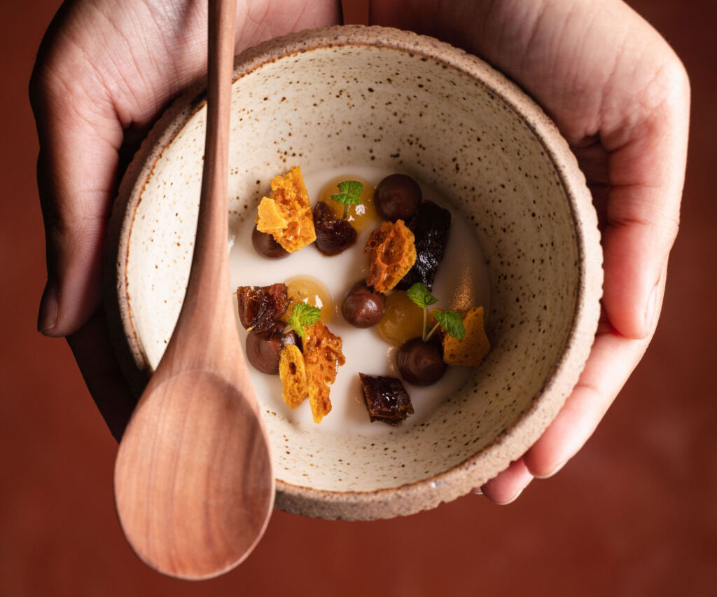 Tiger nut panna cotta with smoked chocolate ganache, honeycomb, dates cooked in rum, dark chocolate and caramel brittle.⁠