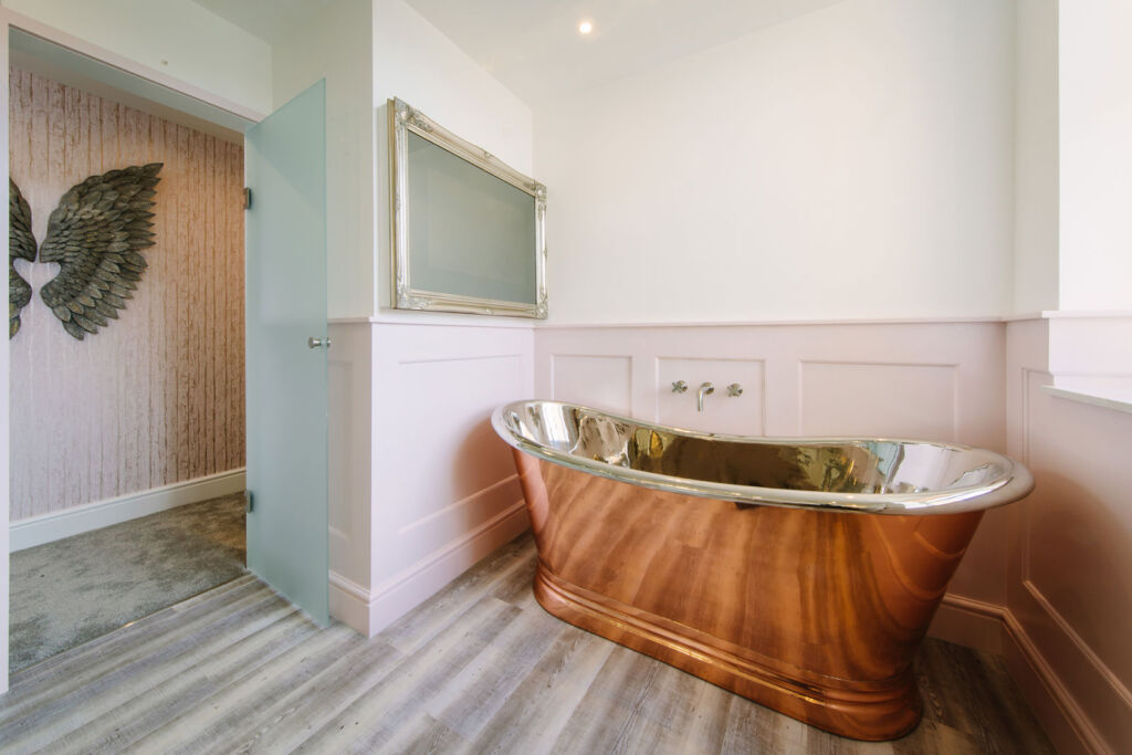 The bathroom with its shiny copper bath in the Parisian Bedroom suite