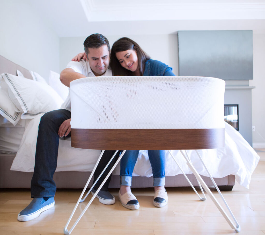 Parents checking on their baby in the SNOO