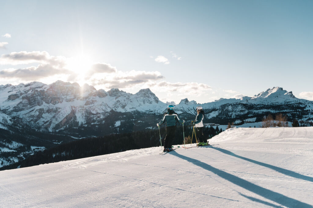 A couple ready to ski down a perfectly prepared slope