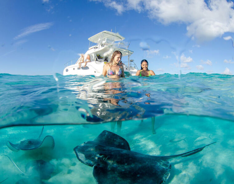 Young ladies meeting stingrays in the Cayman Islands seas