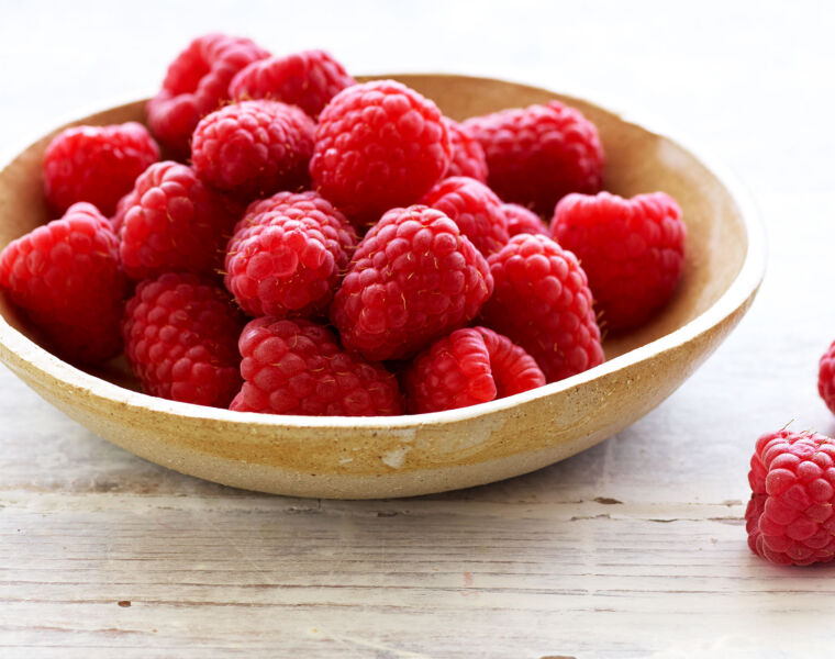 Freshly picked raspberries in a ceramic bowl