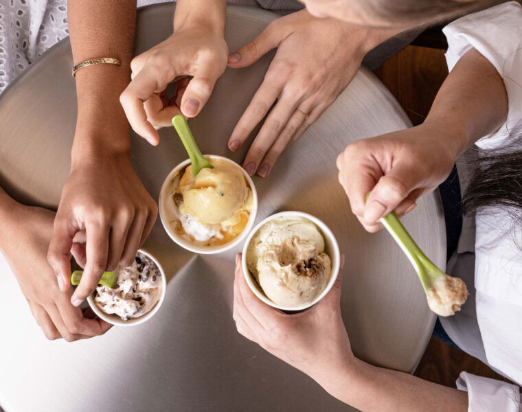 Various desserts in different sized containers being enjoyed by young people