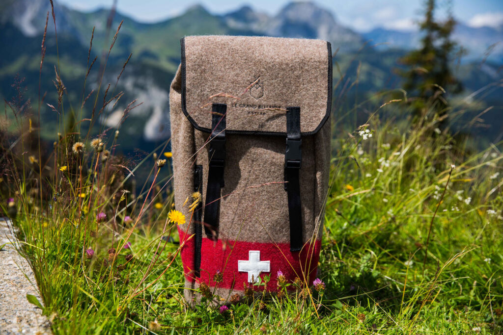 A branded backpack in the countryside with the Swiss flag on its front