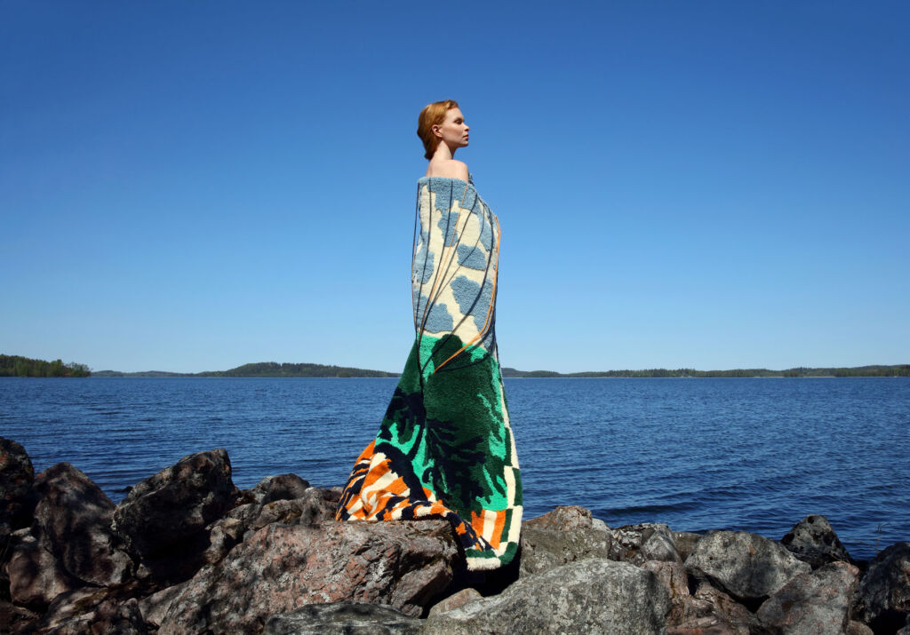 A woman on the sea shore wearing a dress made from recycled textiles