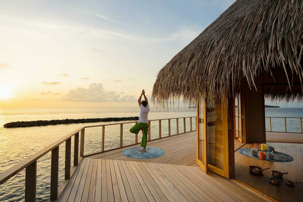 A woman doing a yoga pose at sunrise