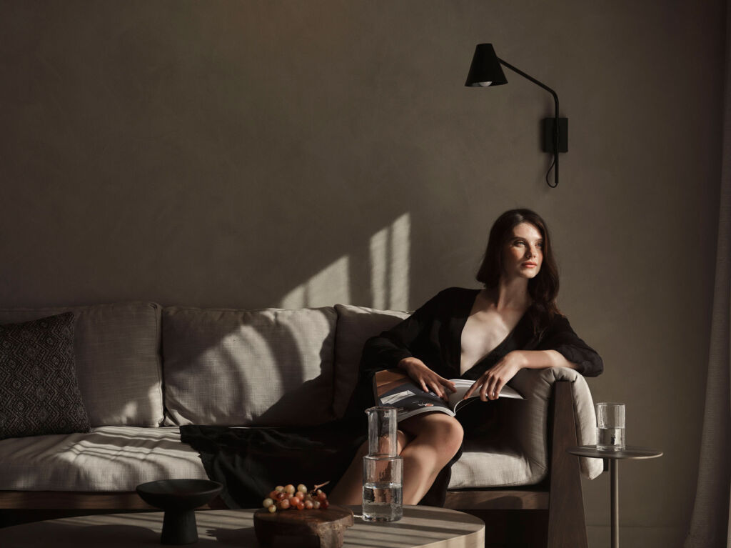 A female guest relaxing on the sofa inside her suite