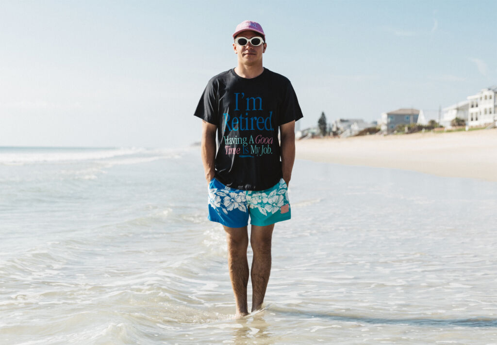 A man standing in the water with a T-shirt stating, "I'm retired, Having a good time is my job"