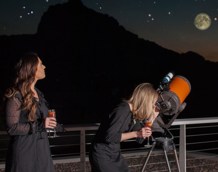 Young woman stargazing with a refractor telescope