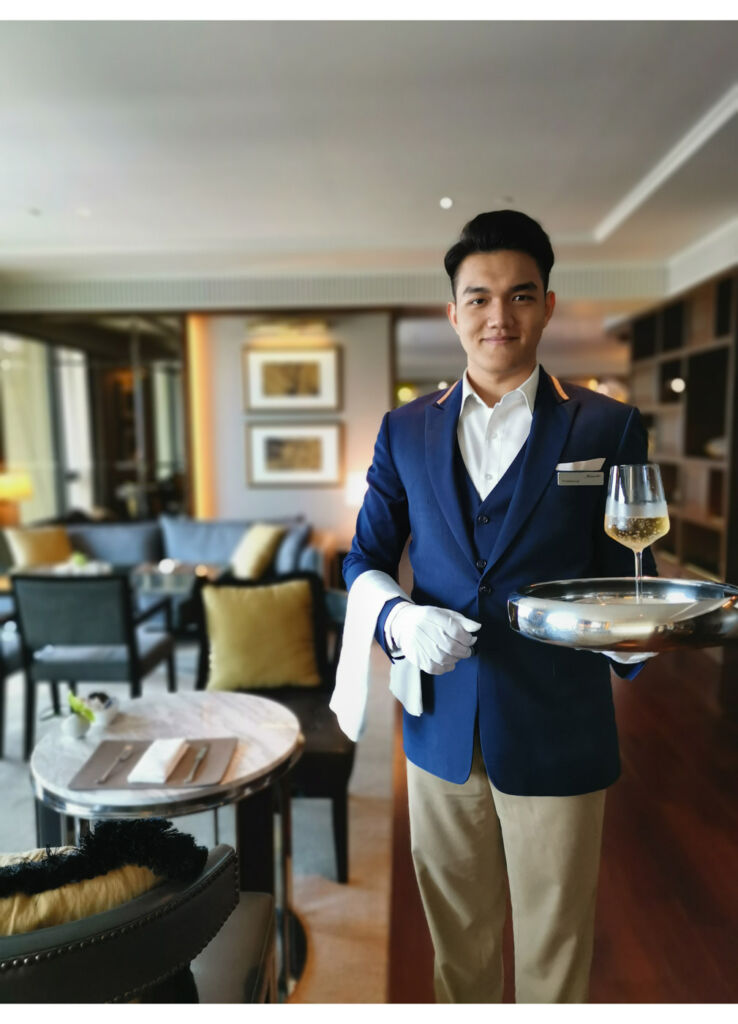 A butler with a refreshing drink on a silver tray