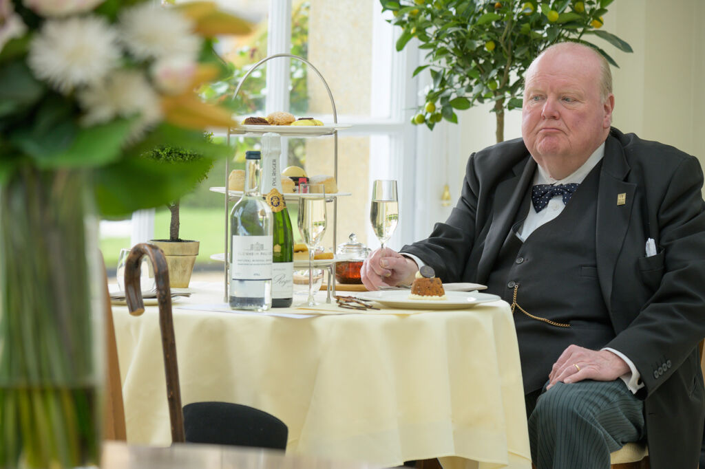 A Churchill look-a-like taking afternoon tea