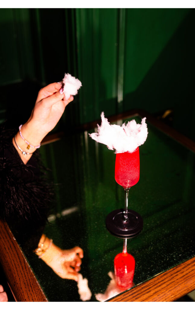 Candyfloss being placed on top of a cocktail