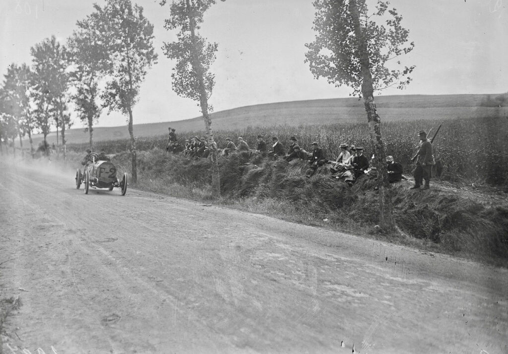 A black and white photograph of the car racing through the countryside