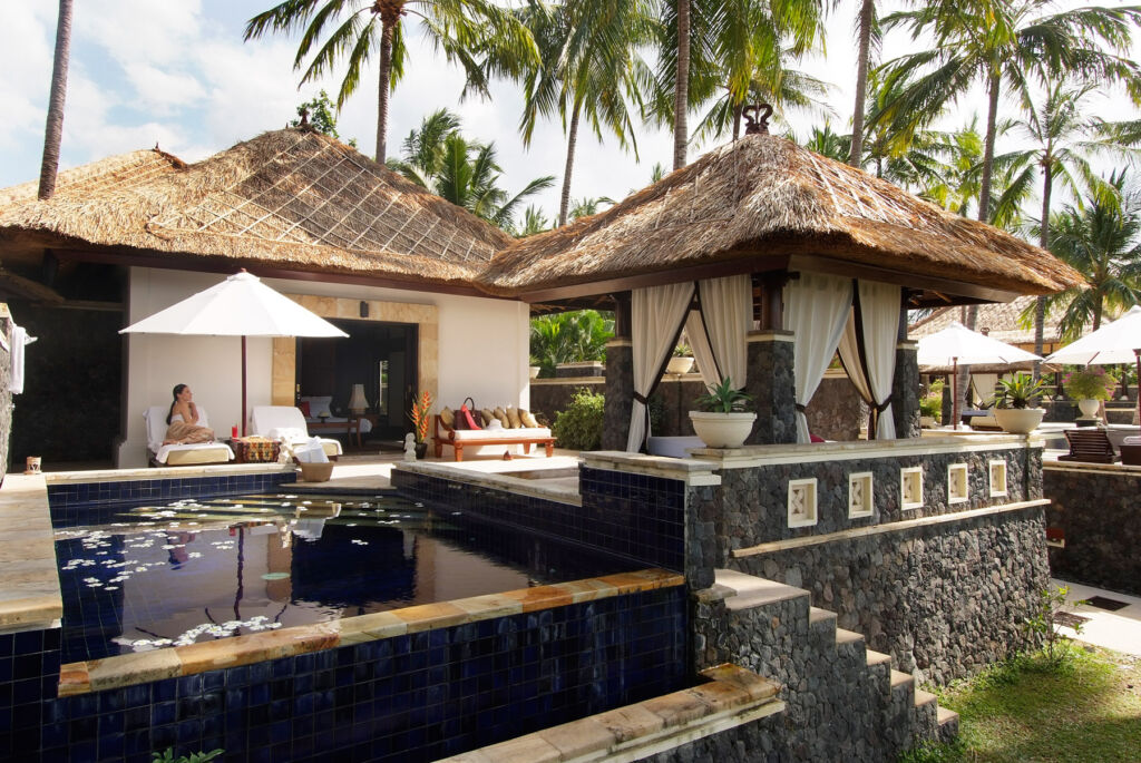 A woman sitting by the pool at her villa