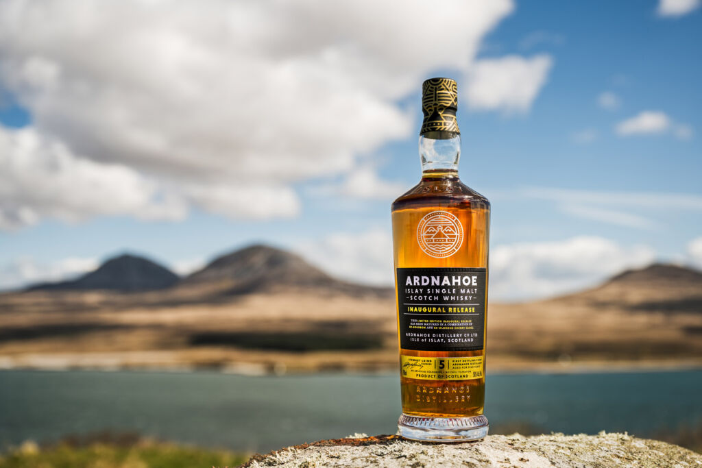 A bottle of Ardnahoe Inaugural Release placed on the shore of a loch