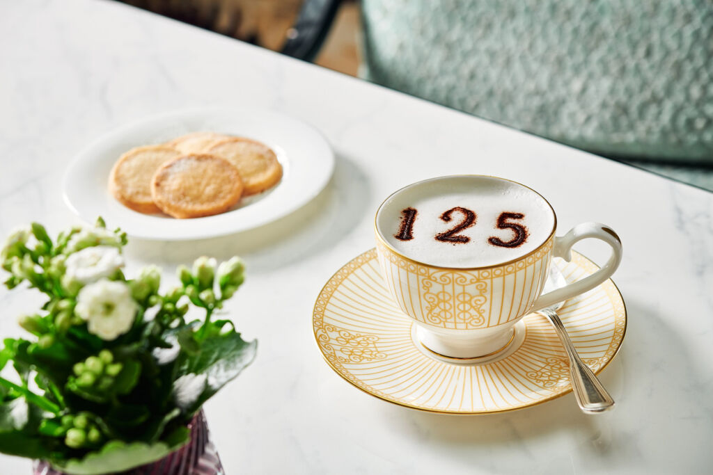 A cup of coffee with the number 125 in the froth