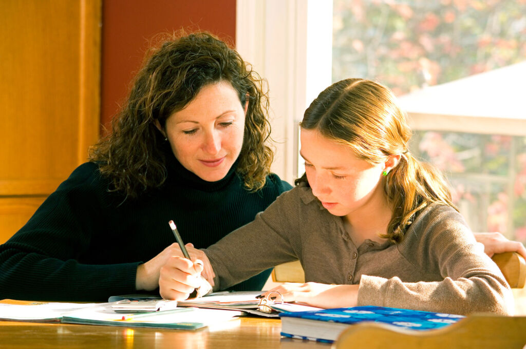 A mother tutoring her daughter at home