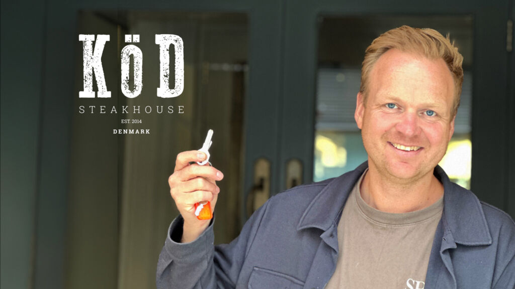 A smiling Morten holding the keys to his first London premises