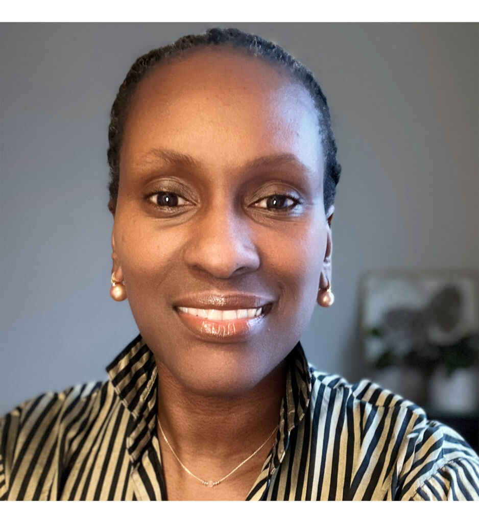 A head and shoulder photograph of Carol-Mae sporting a broad smile