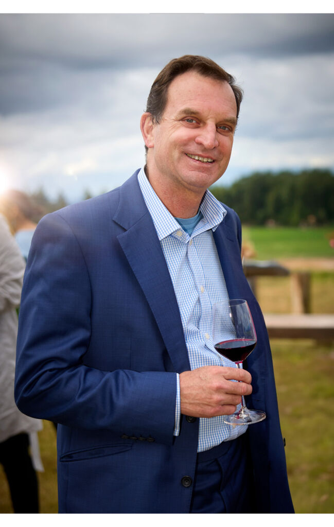 A photograph of Charles holding a glass of wine
