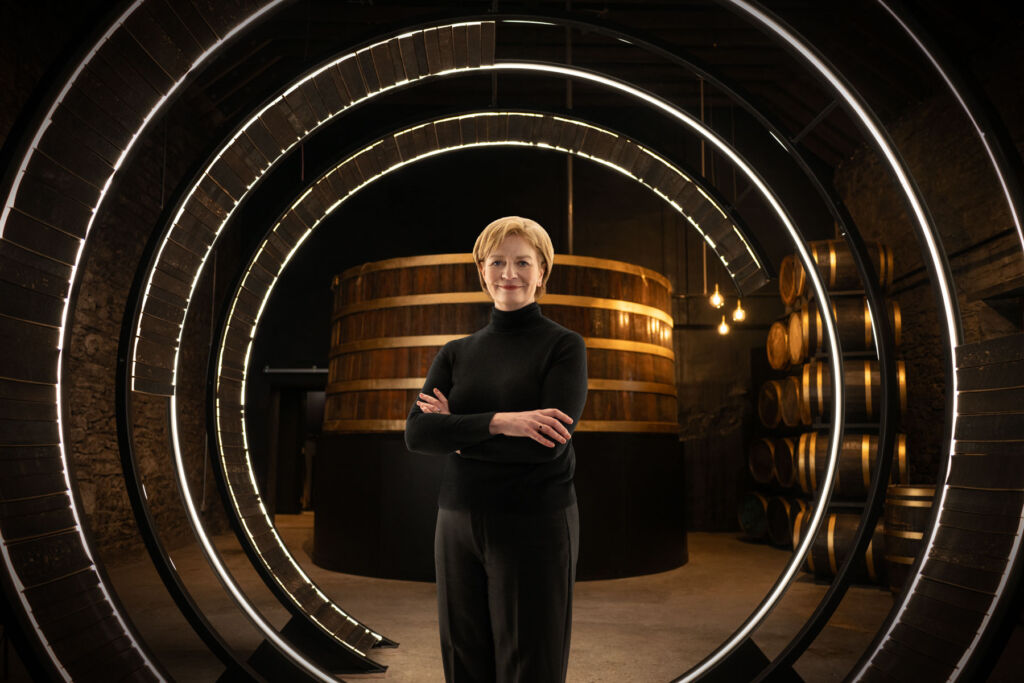 A photograph of Stephanie standing inside one of the giant display barrels