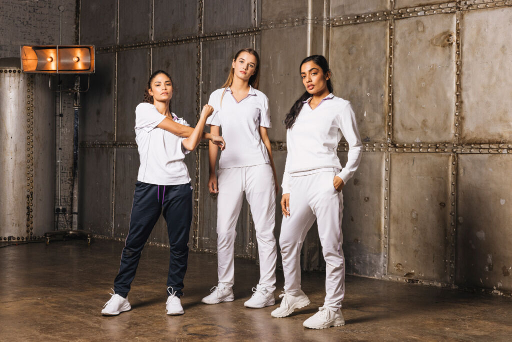 A photograph of three teenage girls wearing the cricket clothing