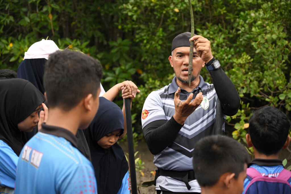 Children being shown the sapling and taught about its benefits