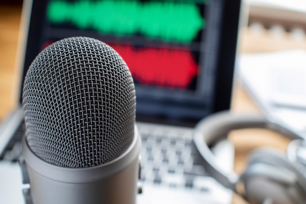 A microphone, notebook and earphones on a desk