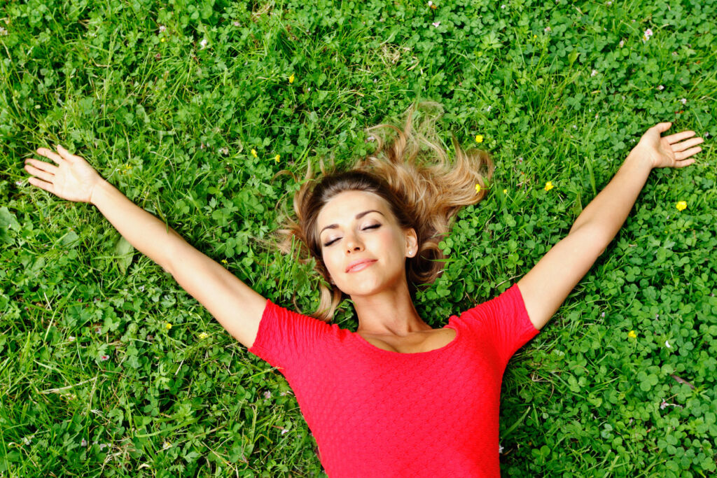 A relaxed woman laying on the grass