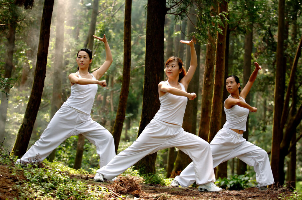 Three woman doing Tai Chi in a forest