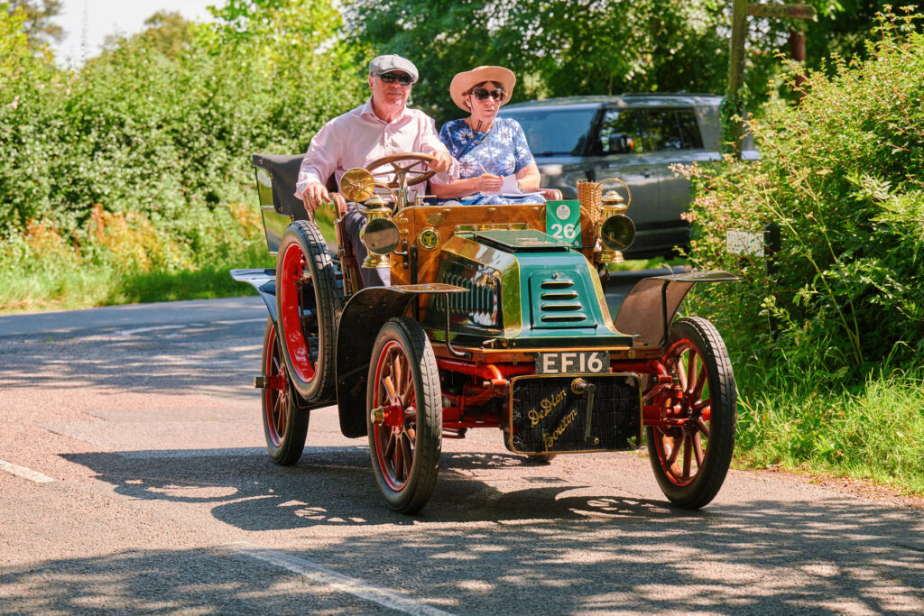 A couple driving a greer coloured vintage car