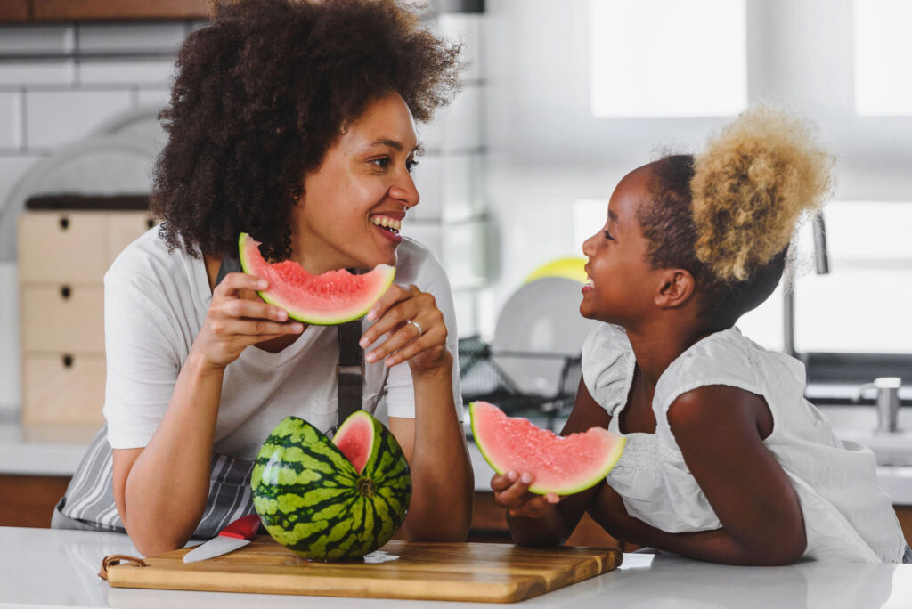 A mother and daughter enjoying slices of watermelon