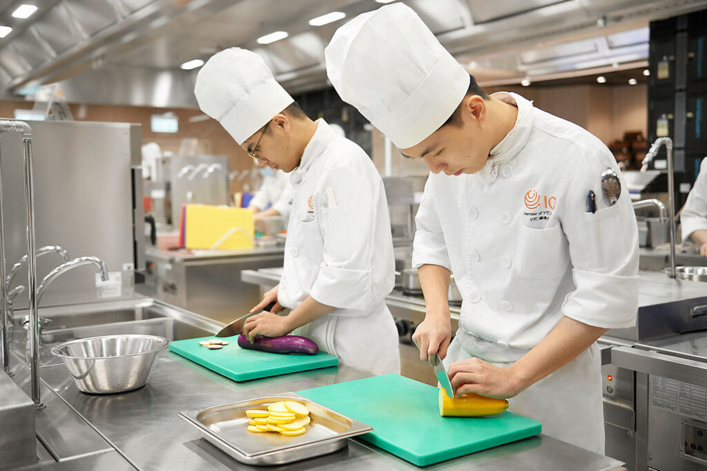 Two young chefs in their whites in the kitchen