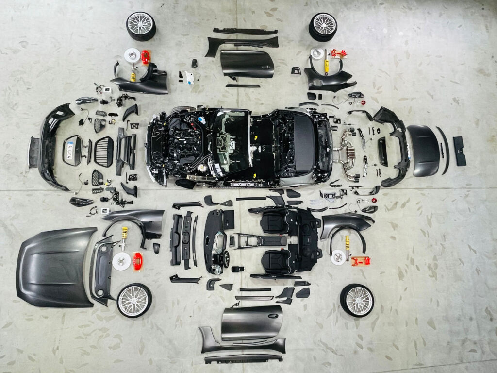 The parts of the car laid out on a concrete floor