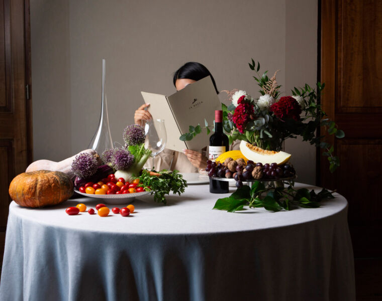 A guest at a table reading the La Rocca menu