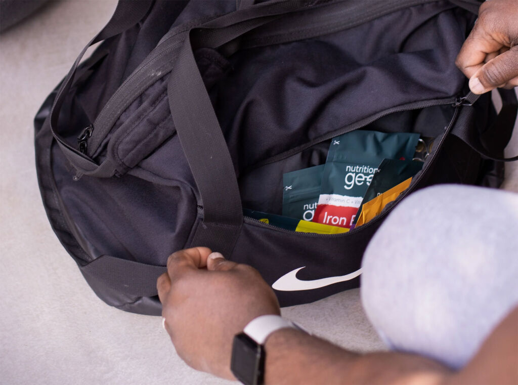 A man with supplement packets in his sports bag