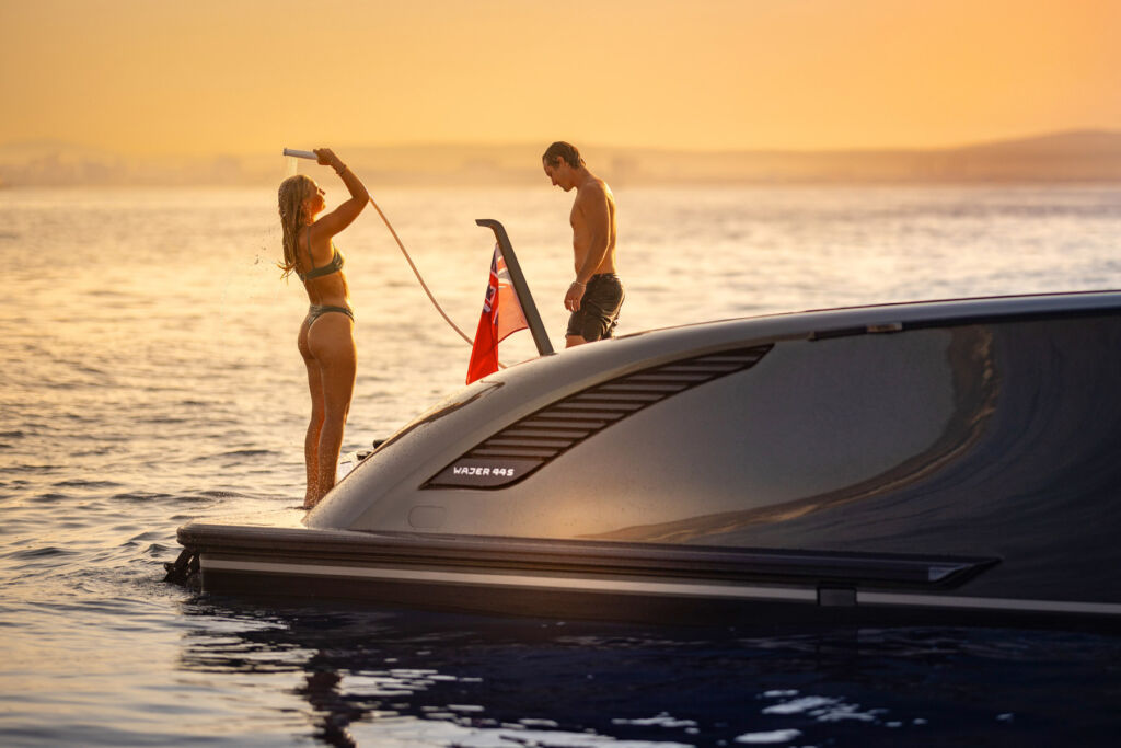 A couple taking a shower at the rear of the boat