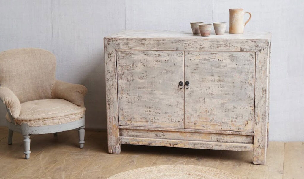 A wheat coloured chair and wooden sideboard from Cart House