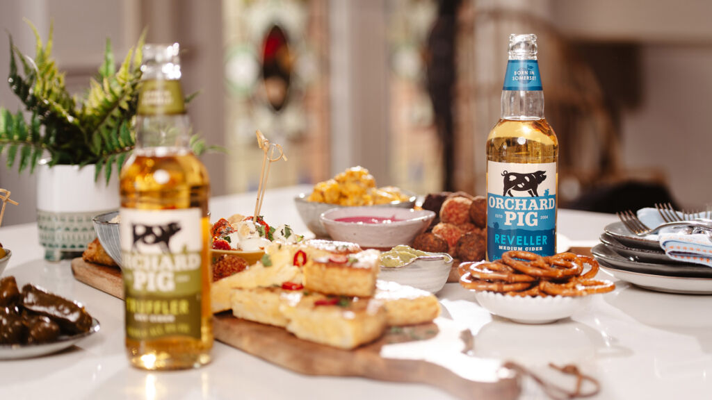 Bottles of cider with plates of comfort food