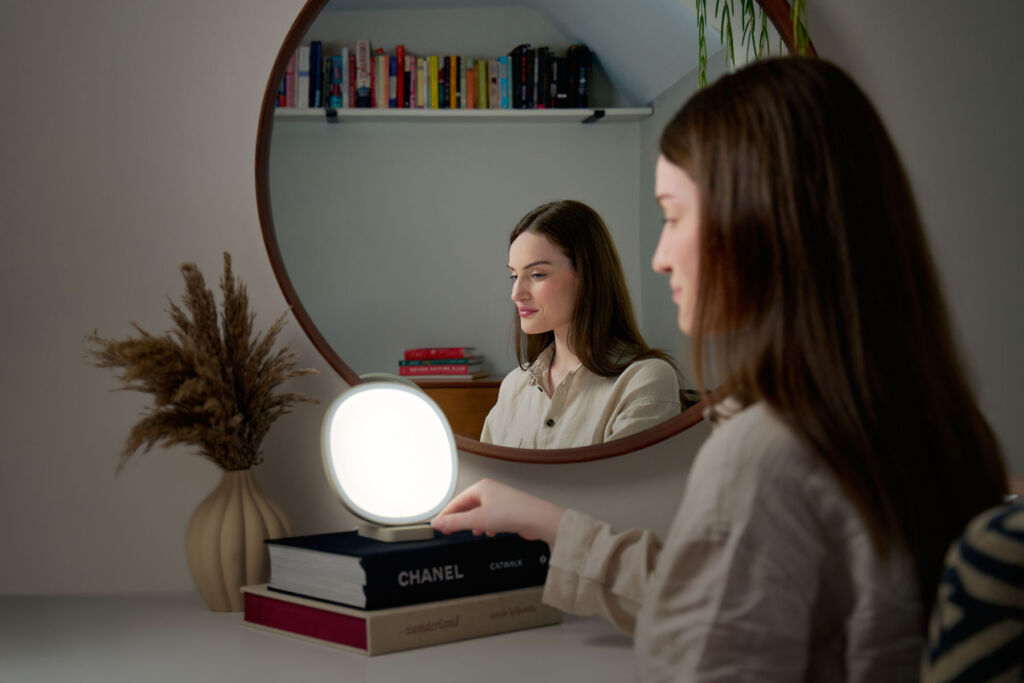 A woman using the light in front or a mirror