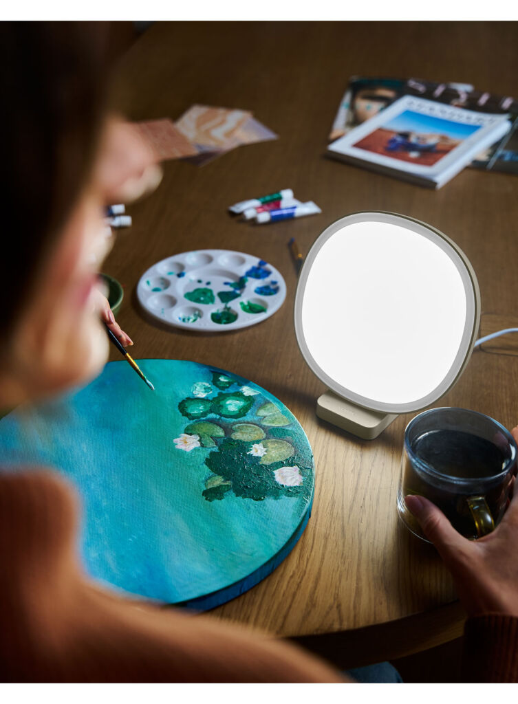 An artist using the light to help mix paints