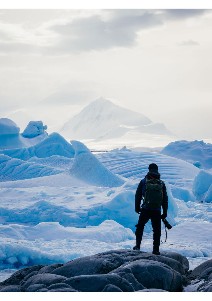 A photographer standing on the ice, taking in the view