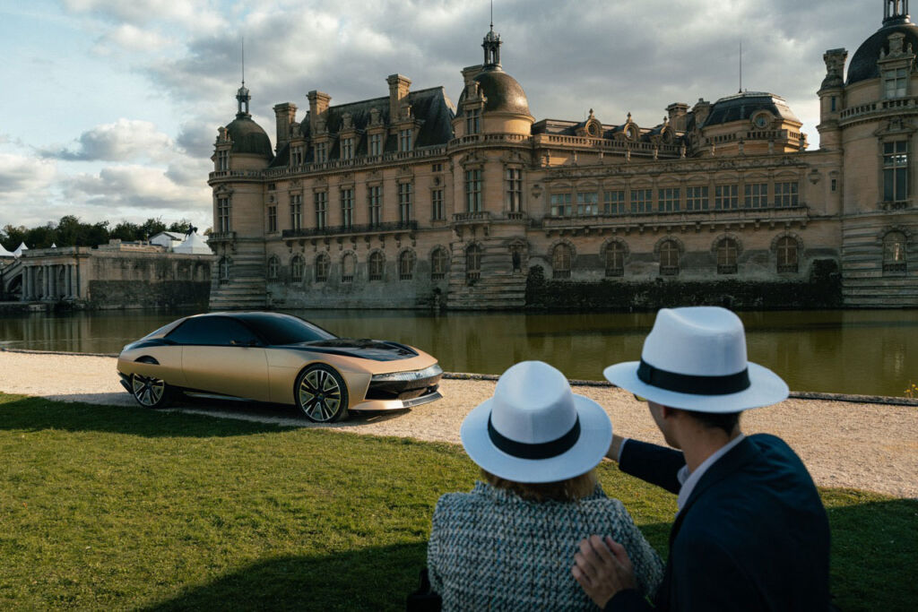 One of the concept cars driving in front of the historic property