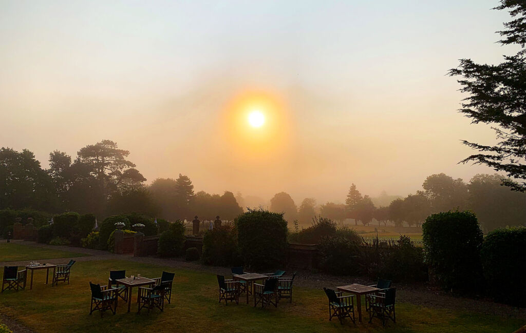 A photograph of the sun rising over the grounds