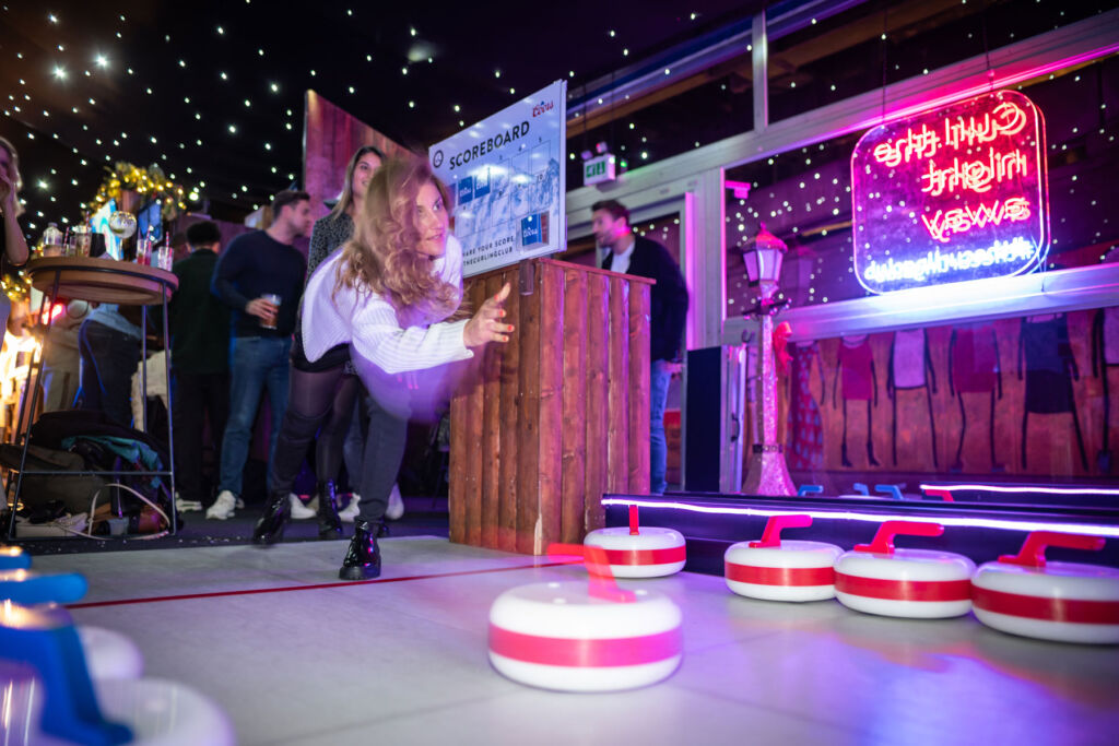 A female player sending a stone down a lane