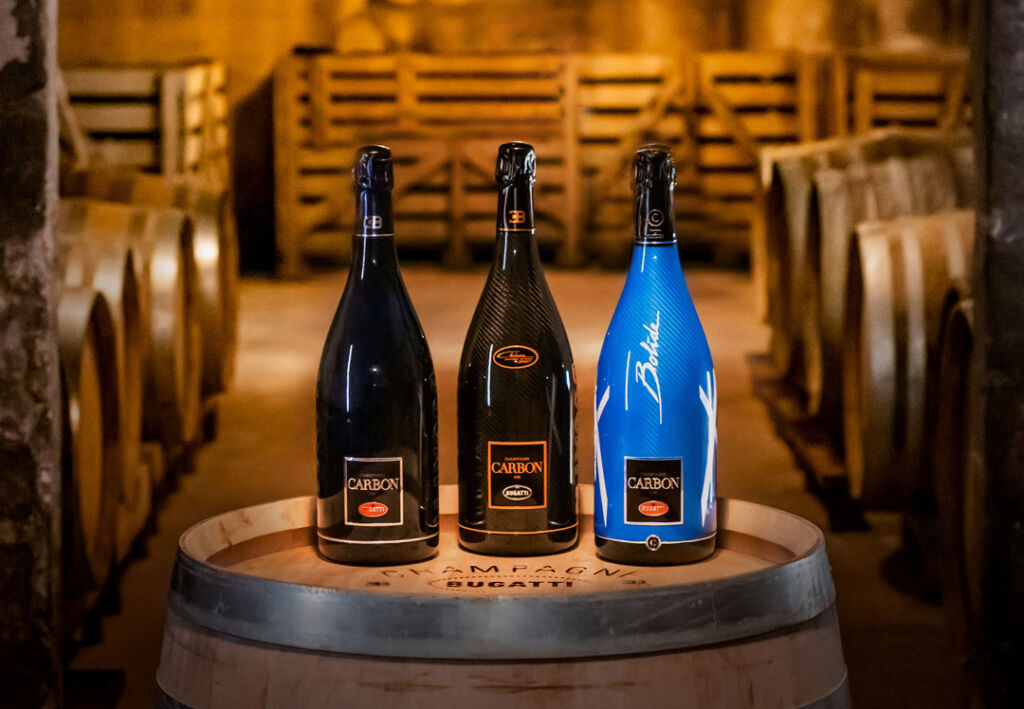 The ƎB.01, ƎB.02, ƎB.03 bottles created for Bugatti placed on a barrel